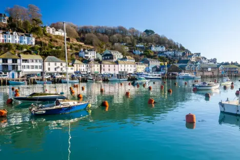 Looe, Cornwall harbor with boats and buildings.