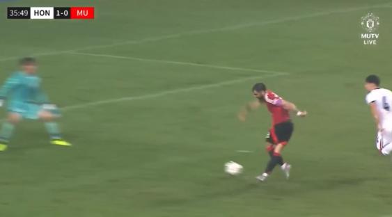 Soccer player dribbling the ball past a defender.