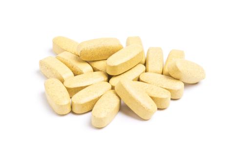 Pile of yellow multivitamin pills.
