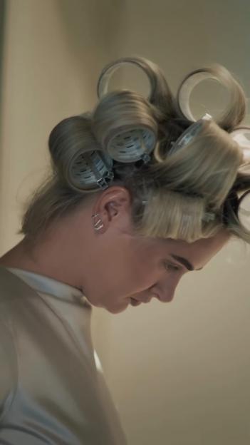 Molly-Mae Hague with hair rollers, looking down.
