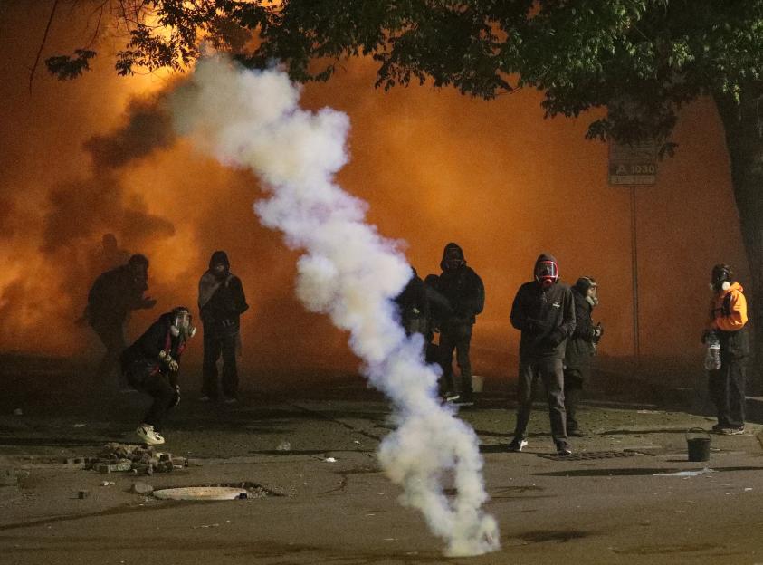 Protesters react to tear gas during an opposition rally.