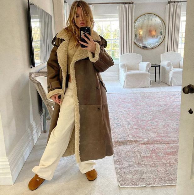 Abbey Clancy in her home, wearing a brown sheepskin coat.