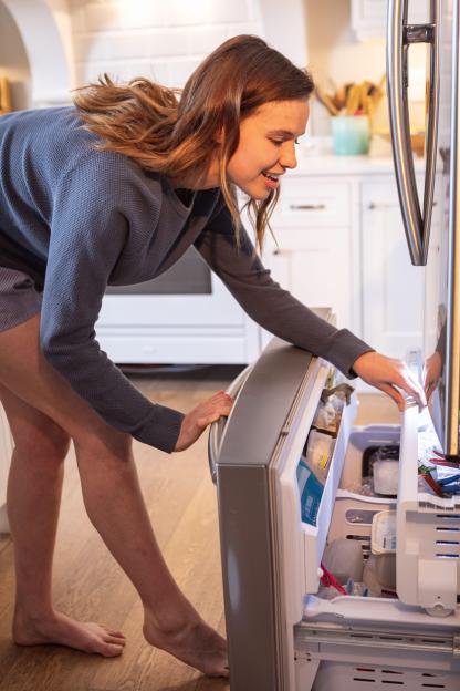 2C6JJEG Woman opening the fridge at home
