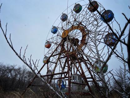 Rusty Ferris wheel in an abandoned amusement park.