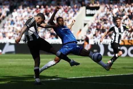 Newcastle United's Bruno Guimarães shoots at goal during a soccer match.