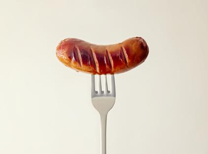 Grilled sausage on a fork.