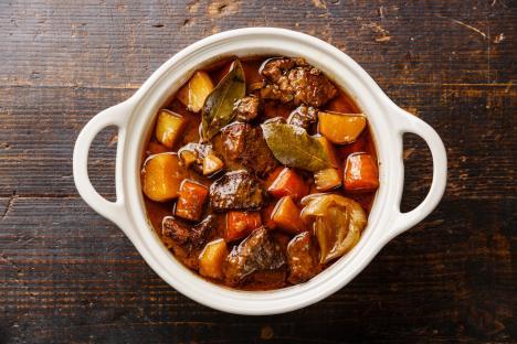 Beef stew with potatoes and carrots in a ceramic pot.
