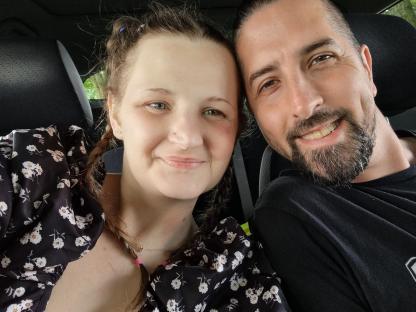 Close-up selfie of a woman and man in a car.