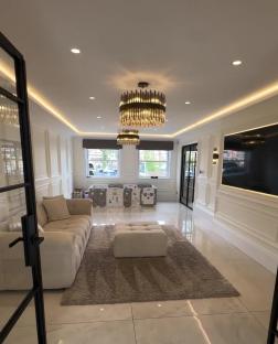 Playroom with beige sofa, light grey rug, and children's play area.