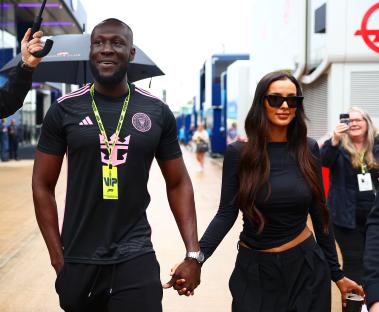 Stormzy and Maya Jama holding hands at a racetrack.