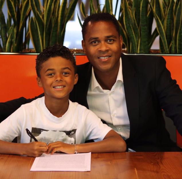 Patrick Kluivert and his son Shane signing his first Nike contract.