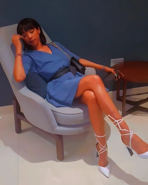 Illustration of a woman in a blue dress sitting in a chair.