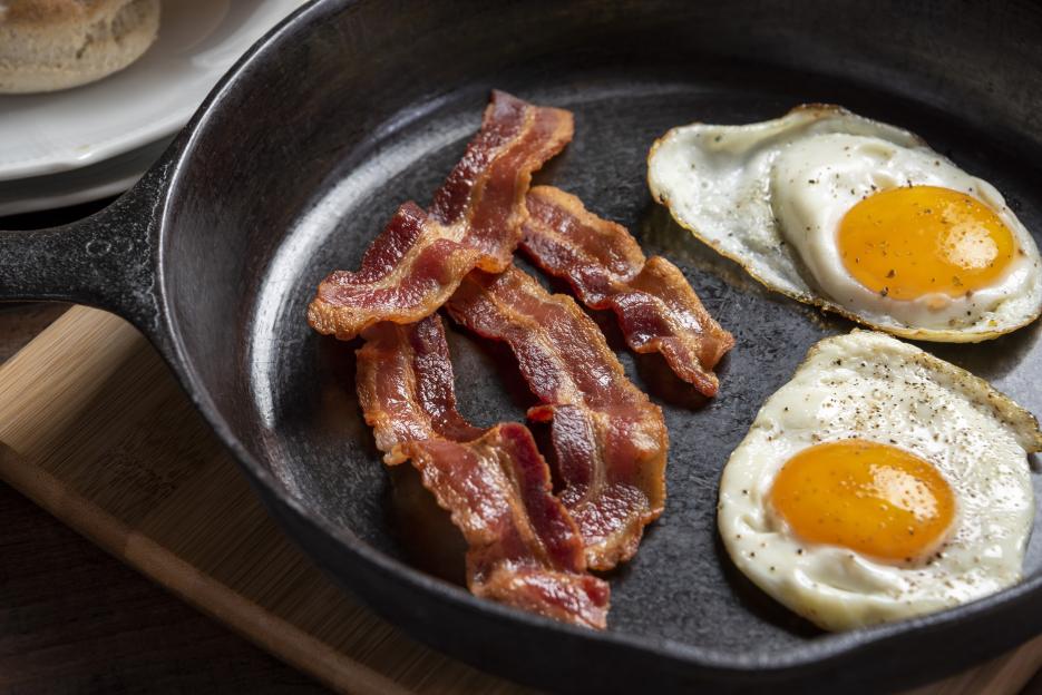 Bacon and eggs served in a cast iron skillet.