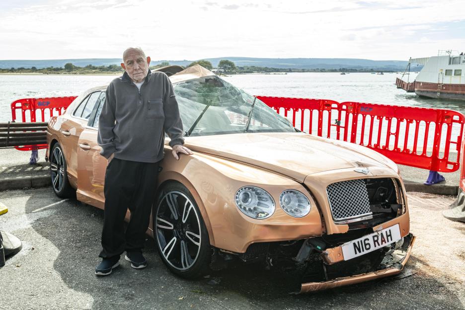 Robert Hill next to his Bentley after it plunged into a harbor.