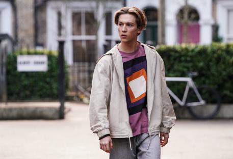 Joel from EastEnders walking down a street.
