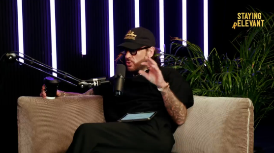 Man sits on couch during podcast interview.