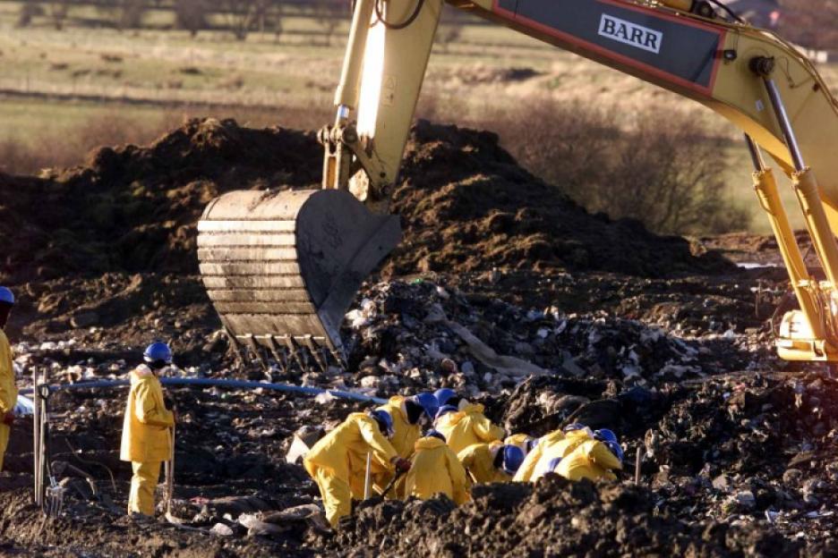 Headline: BARRY COPS DIG UP TIP IN BODY HUNT
Caption: Grim task...officers watch as digger sifts rubbish tip in hunt for the torso of missing Barry
Police search for the remains of Kilmarnock murder victim Barry Wallace at Garlaff landfill site near Cumnock. Pic:Andy Barr
