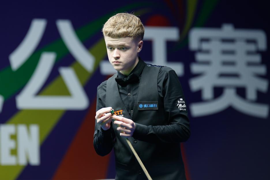 Stan Moody of England chalks the cue during a quarterfinal snooker match.