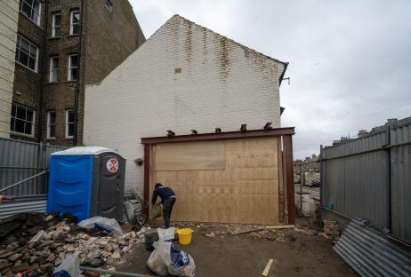 Construction worker removing debris from a building site.