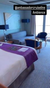 Ambassador Cruise Line suite with bed, sofa, and chairs.