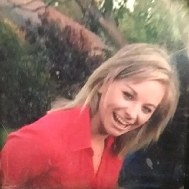 Photo of a woman in a red shirt in a decorative frame.