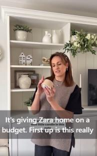 Woman holding a candle, similar to a Zara Home candle.