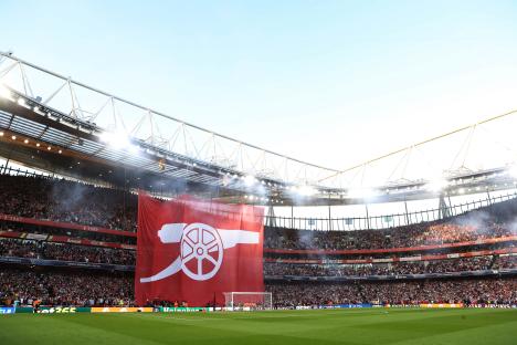 Large Arsenal flag unfurled in a packed stadium.