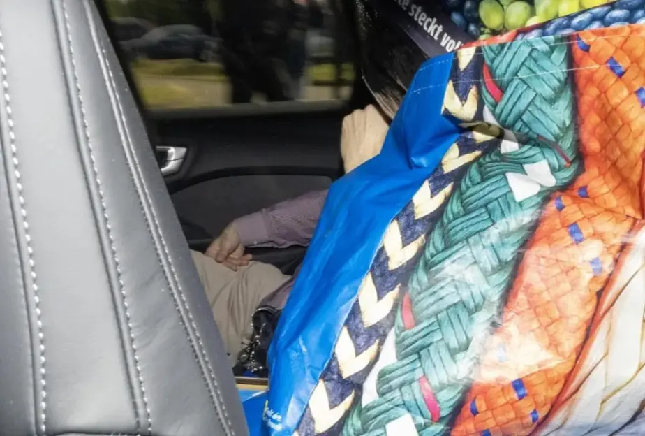 Person in the back seat of a car.