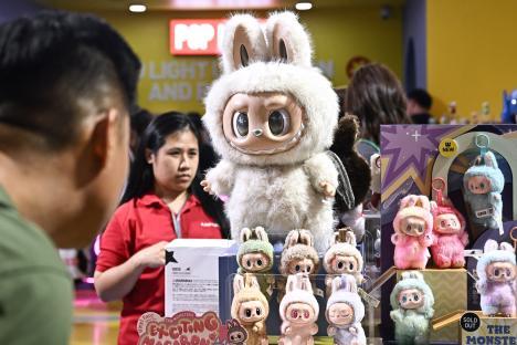People looking at Labubu designer art toys at a Pop Mart pop-up shop.