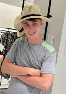 Photo of Jay Slater wearing a gray shirt and straw hat.