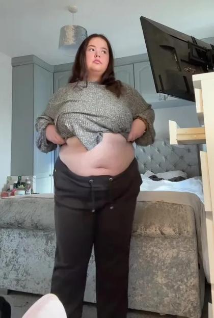 Woman showing her stomach after weight loss.