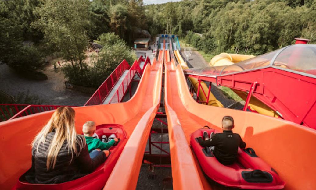 People riding a water slide at Greenwood Family Park in Wales.