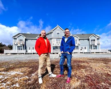 Colin McAllister and Justin Ryan standing in front of a Canadian hotel they are renovating.