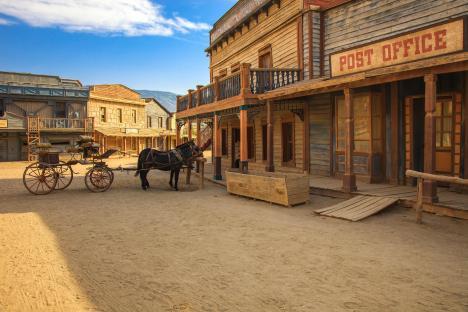 Horse-drawn carriage in front of a Western-style post office.