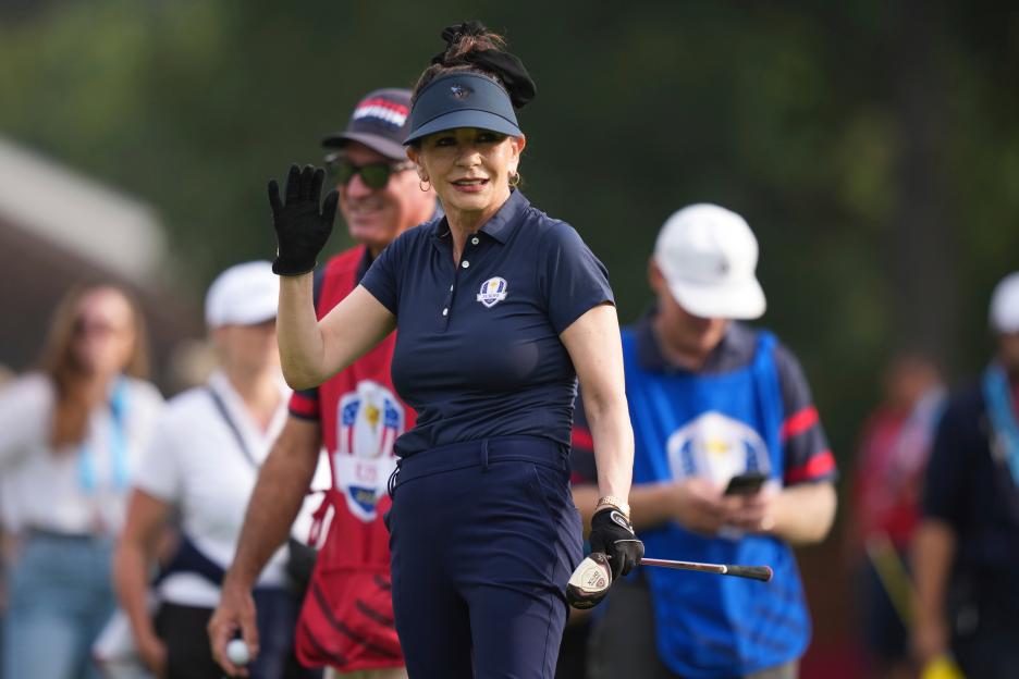 Catherine Zeta-Jones waving on the golf course.