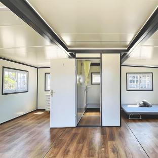 Interior of a tiny home with a bathroom and a bed.