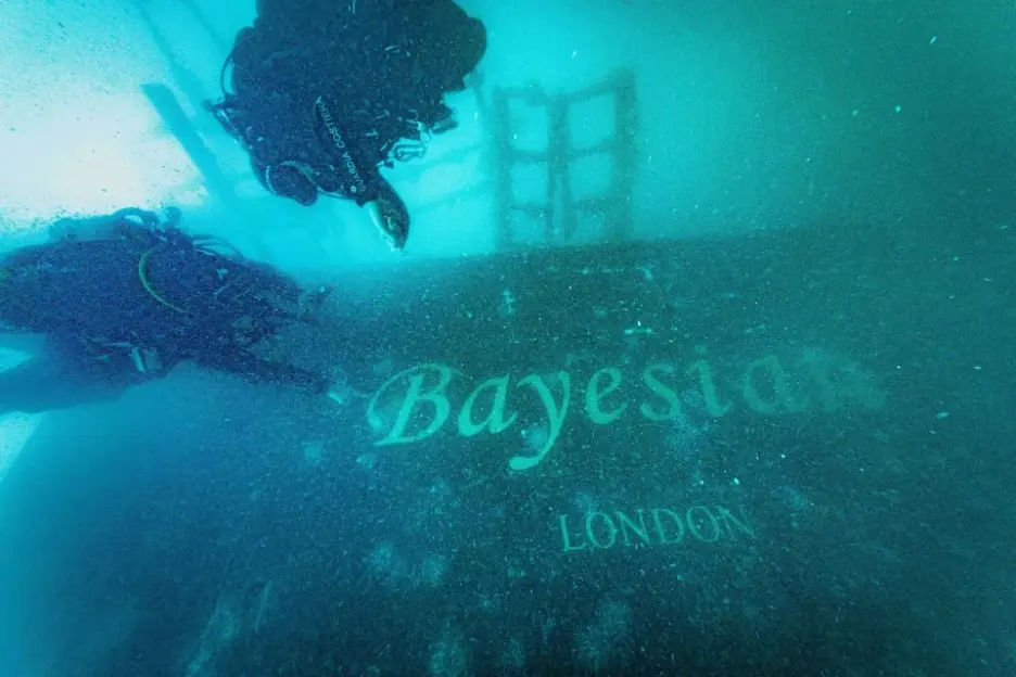 Divers exploring the submerged "Bayeston London" shipwreck.