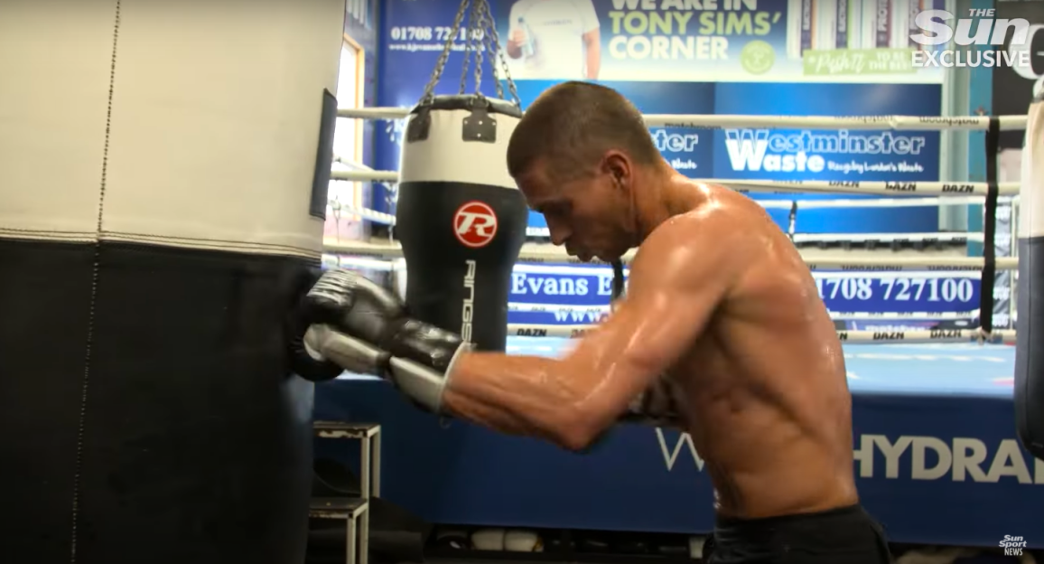 Boxer training with punching bag.