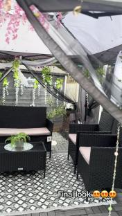 Decorated garden patio with black wicker furniture.