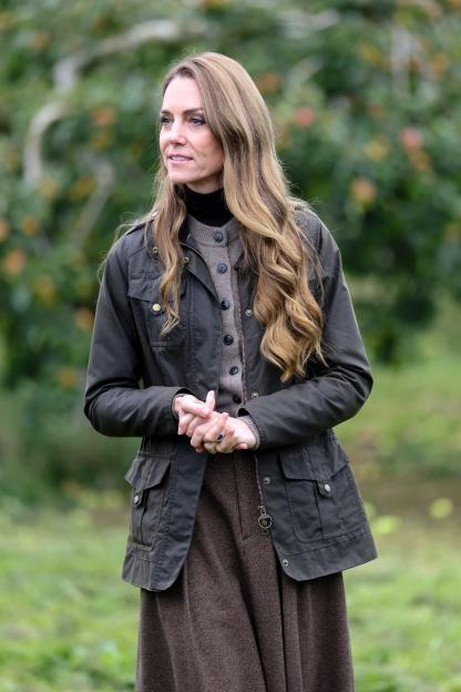 Catherine, Princess of Wales, in a Barbour jacket and brown skirt, tours Long Meadow’s orchards.