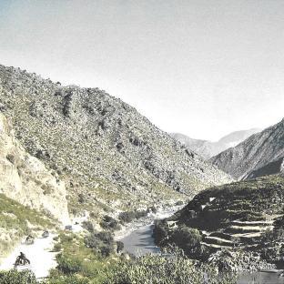 Vehicles traveling through a mountainous Afghan valley.
