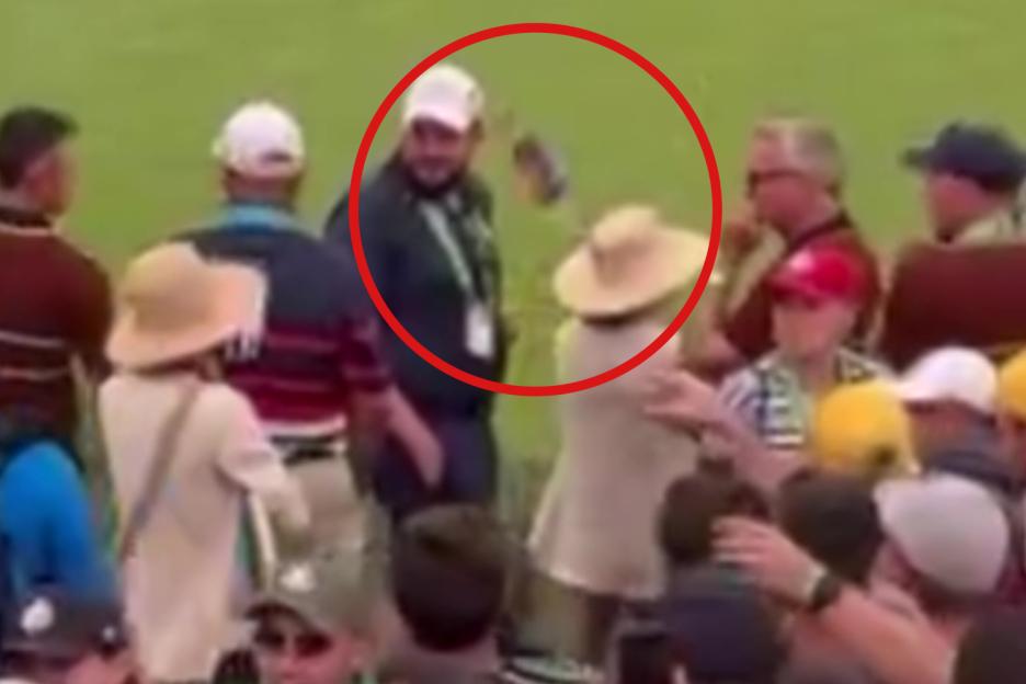Patrick Cantlay's caddie Joe LaCava being splashed with water by a spectator.
