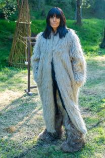 Claudia Winkleman in a long, fluffy coat and furry boots.