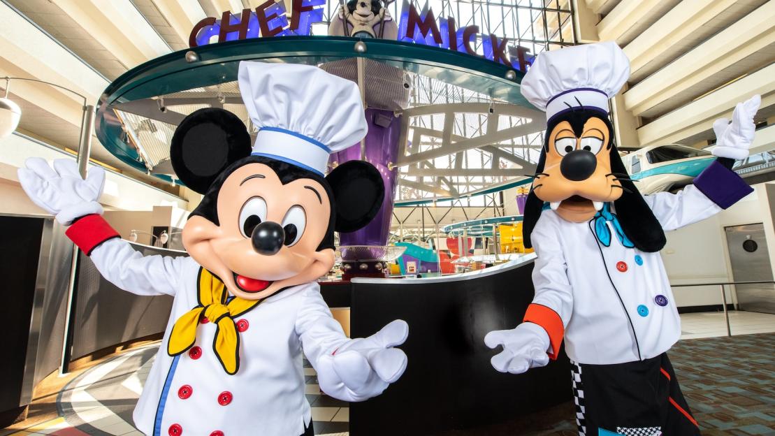 Mickey Mouse and Goofy in chef costumes with the "Chef Mickey" sign in the background.