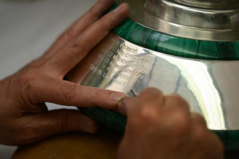 Engraving Liverpool F.C. on the Premier League trophy.