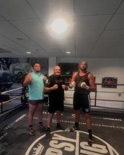 Three boxers in a boxing ring.