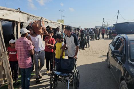 Displaced Palestinians receiving food packages in Rafah, Gaza.