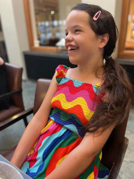 Annabelle, daughter of Kate Skelton, laughing while seated.