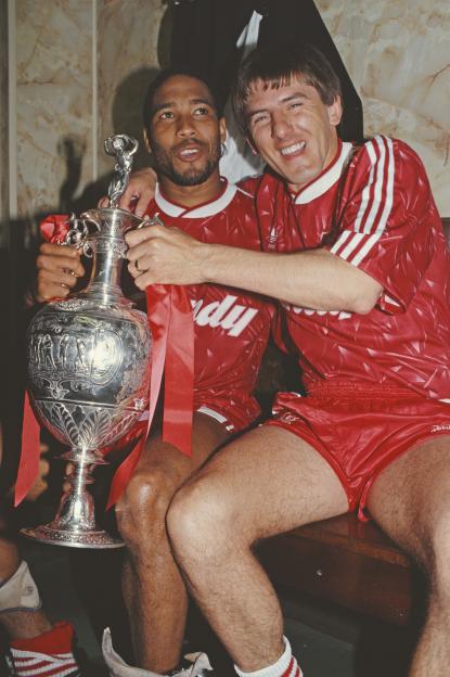 Liverpool players John Barnes and Peter Beardsley celebrating with the First Division Trophy.