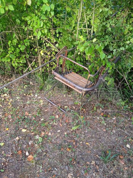 Damaged chairlift seat on the ground.